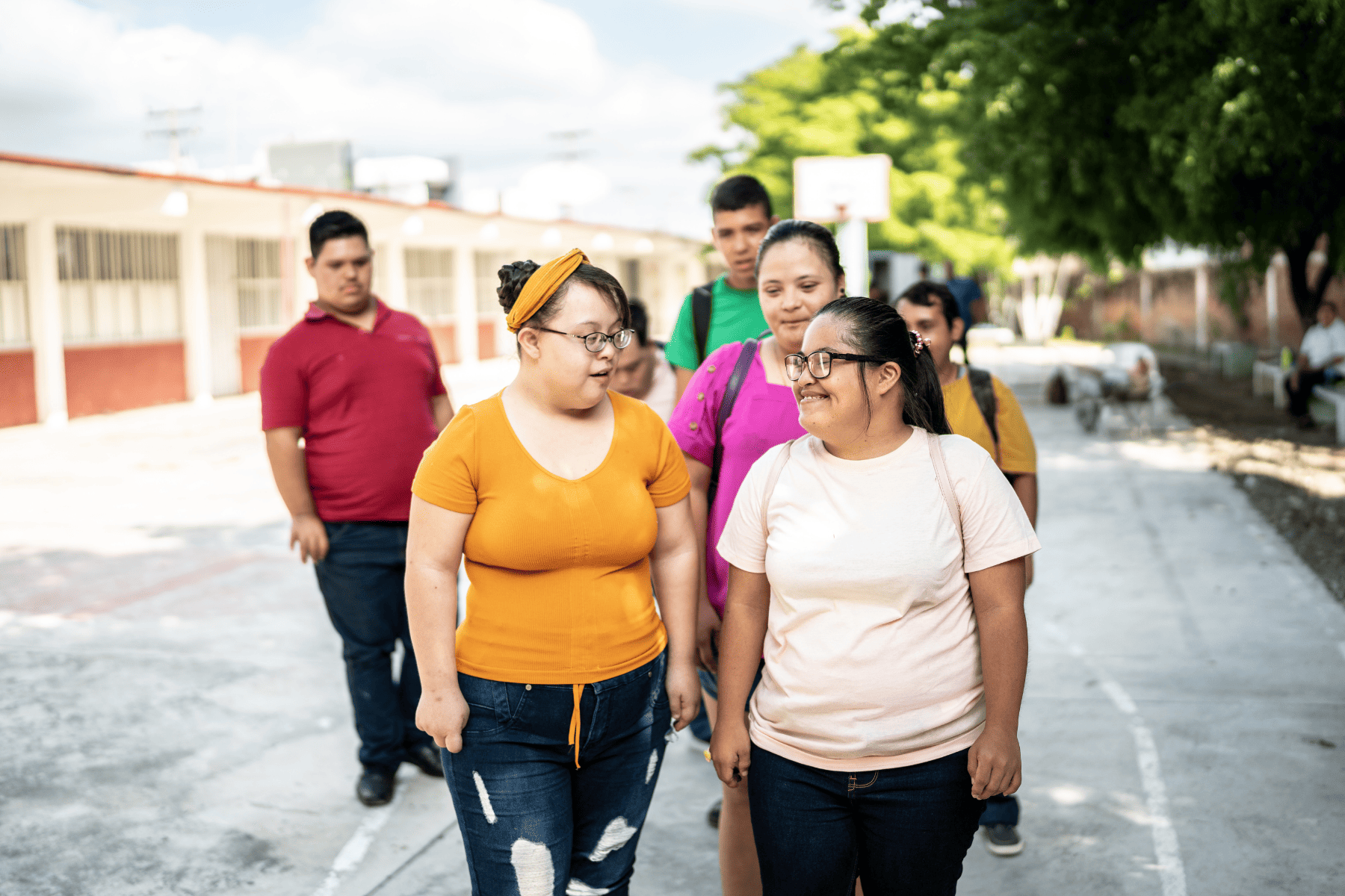 Group of young people with disabilities walking together outdoors in a supportive environment